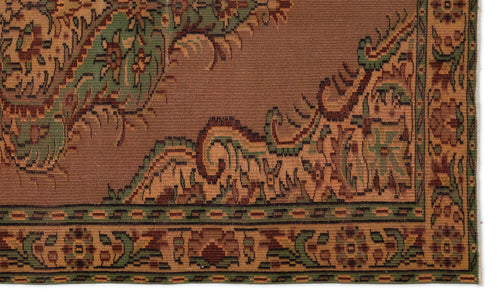 Load image 1 in gallery view. Brown rug with a green and tan floral border and intricate traditional medallion pattern.