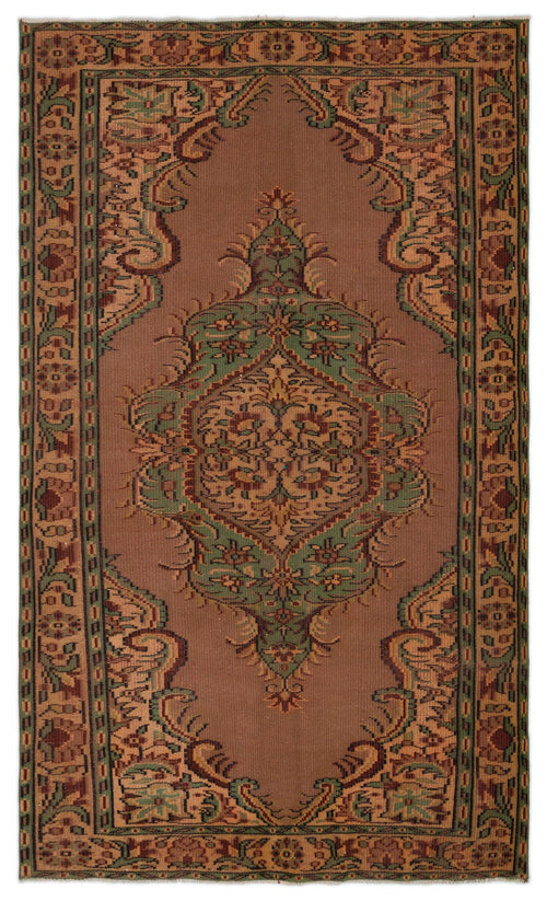 Load image 1 in gallery view. Brown traditional rug with a central green and tan floral medallion and a decorative geometric border.