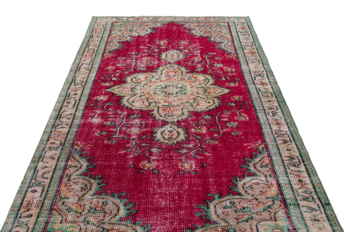 Load image 1 in gallery view. Distressed red vintage-style rug with a central floral medallion and green and beige border patterns.