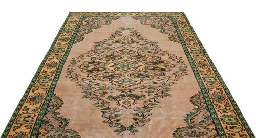 Load image 1 in gallery view. Beige vintage-style rug with a central floral medallion, green and brown accents, and a decorative border.