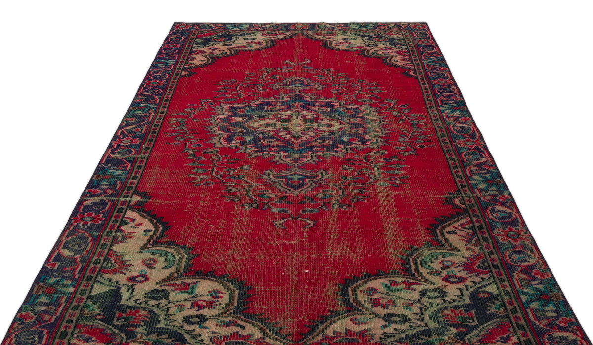 Distressed red traditional rug with a central navy and cream floral medallion and ornate border on a white background.