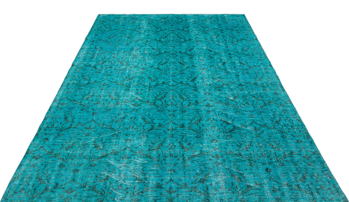 Teal distressed rug with a faded traditional floral medallion pattern on a white background.