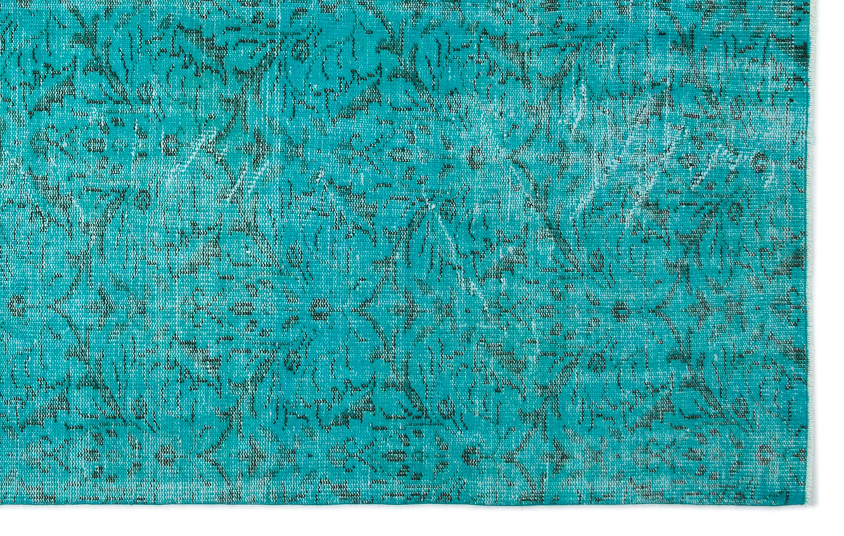 Teal rug with a distressed, dark grey traditional floral pattern on a white background.