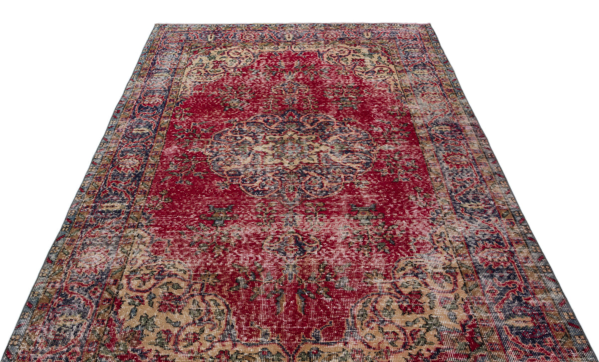Distressed red traditional rug with a central medallion and ornate floral border in navy, cream, and olive tones.