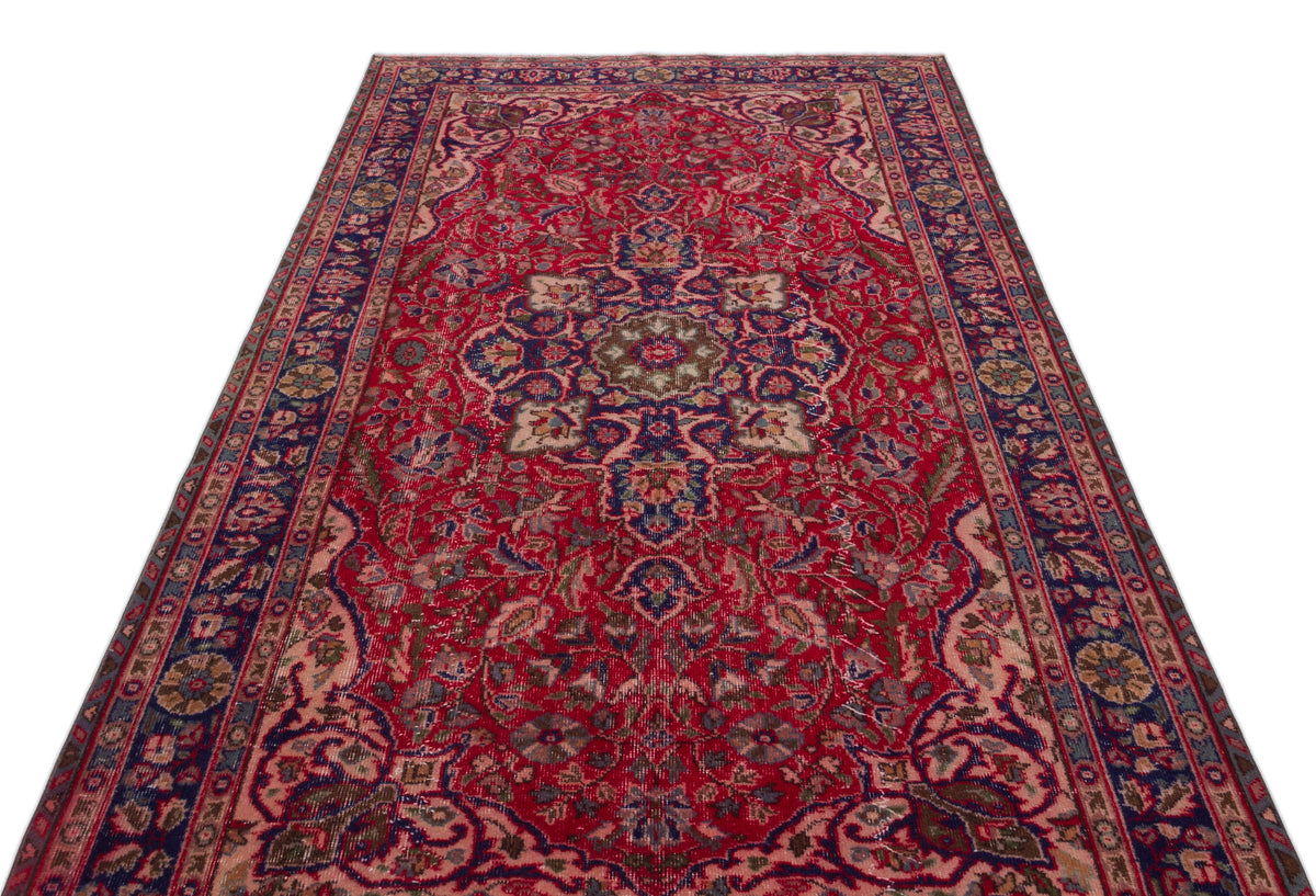 Red and navy blue traditional Persian-style rug with a central floral medallion and intricate border patterns.