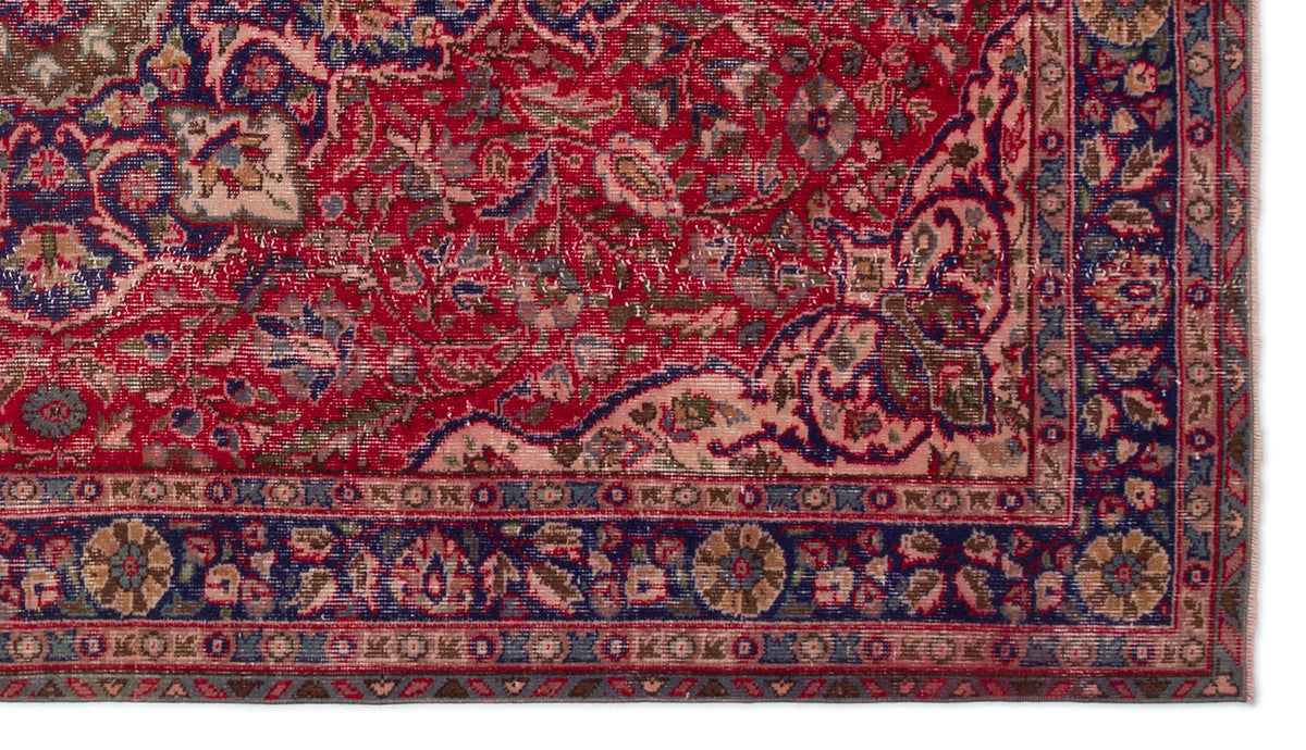 Red, navy, and beige traditional Persian-style rug with an intricate floral medallion pattern and a decorative border.