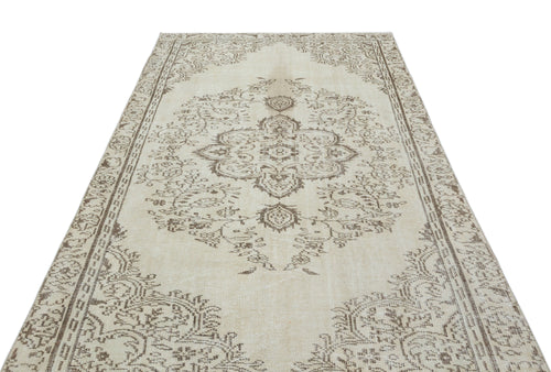 Load image 1 in gallery view. Beige and brown vintage-style rug with a central floral medallion and ornate border on a white background.