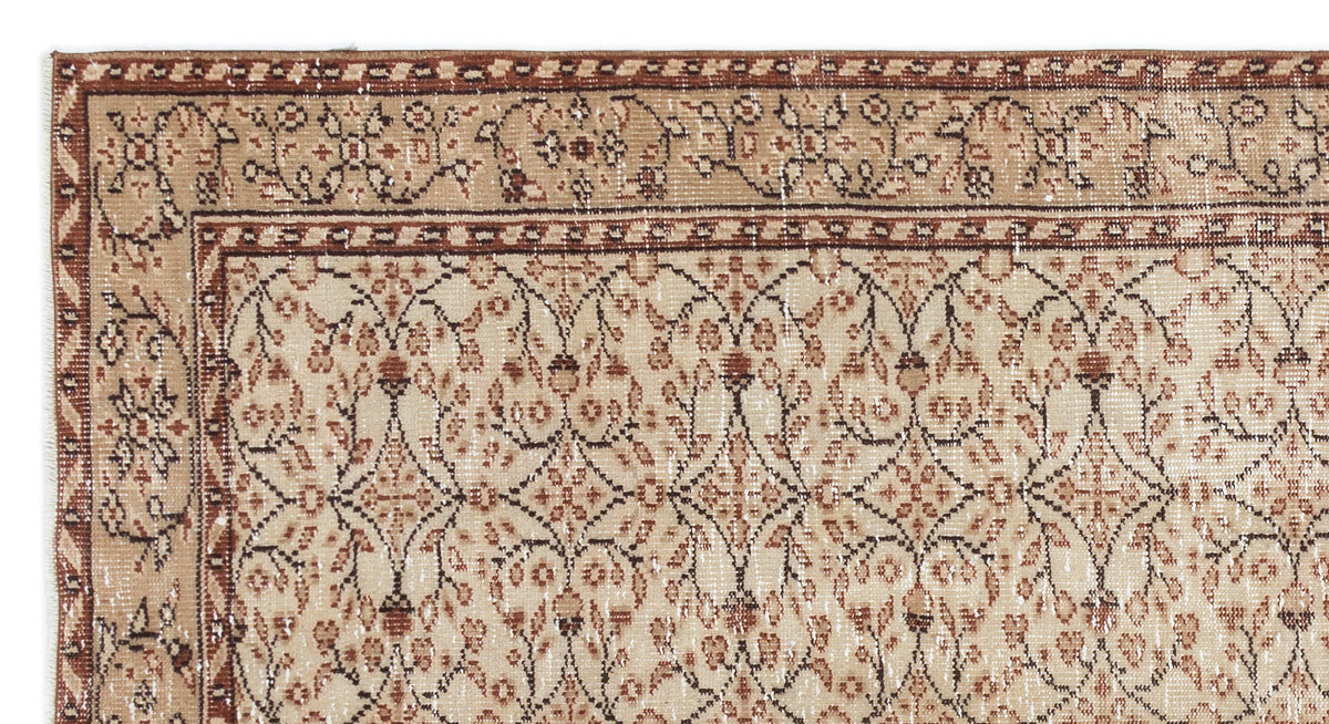 Beige and brown traditional rug with a distressed floral vine pattern and a geometric border.