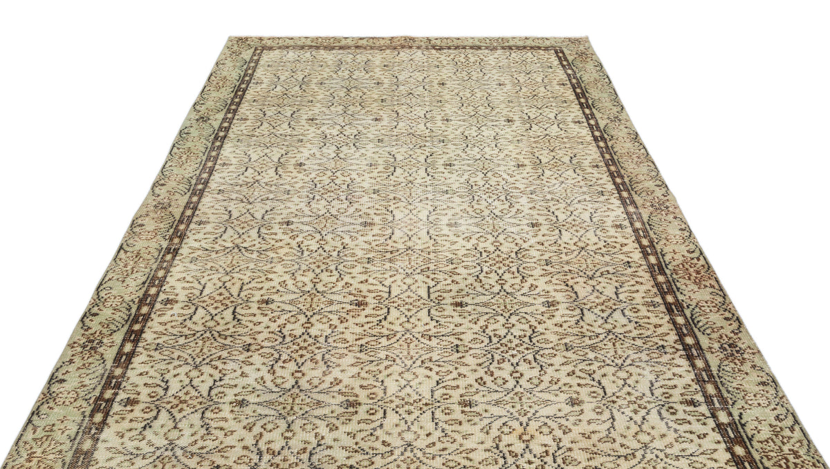 Beige and brown vintage-style rug with an all-over intricate floral pattern and a dark geometric border.