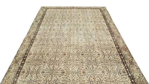 Load image 1 in gallery view. Beige and brown vintage-style rug with an all-over intricate floral pattern and a dark geometric border.