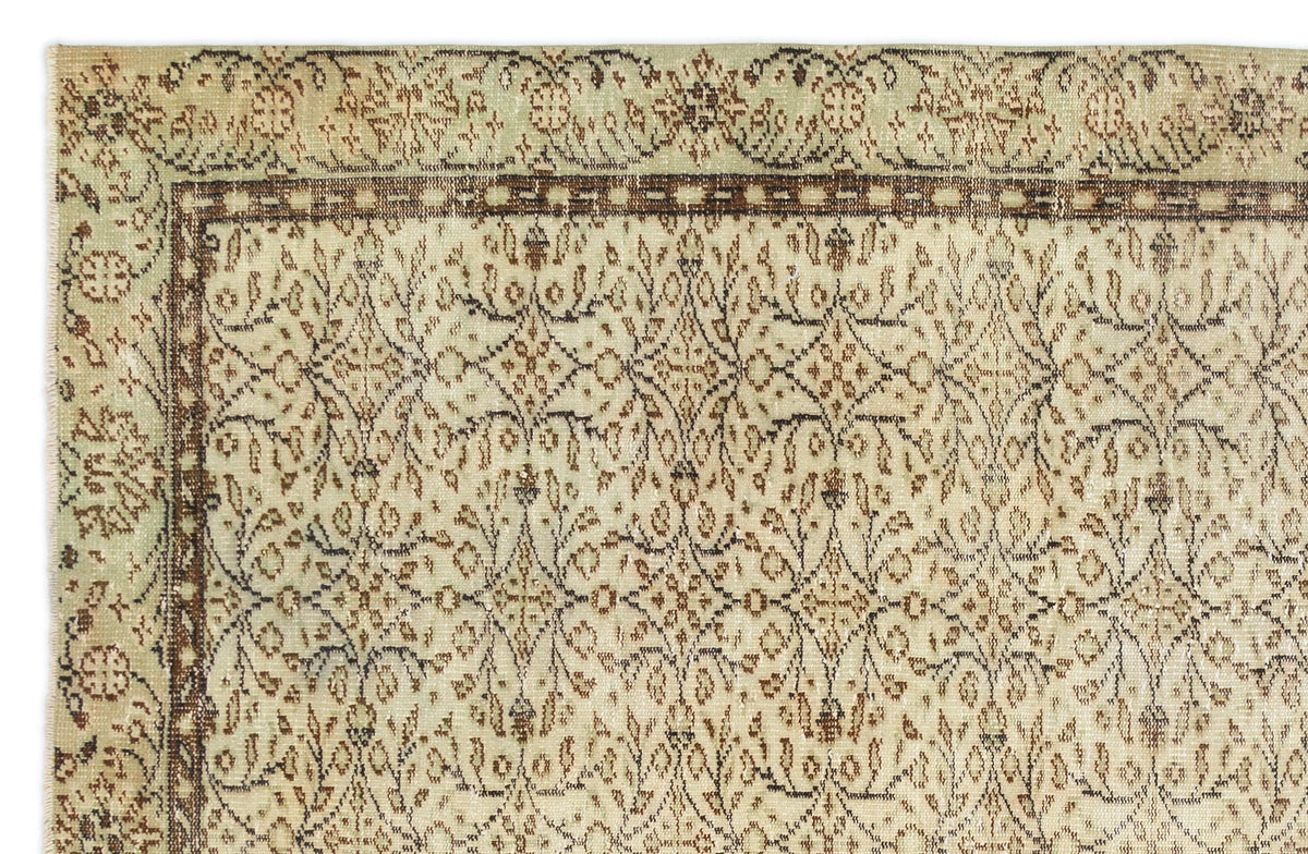 Beige and sage green vintage-style rug with a dark brown floral vine border and intricate central botanical pattern.
