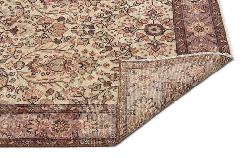 Load image 1 in gallery view. Beige, brown, and mauve traditional floral rug with a folded corner revealing the woven backing.