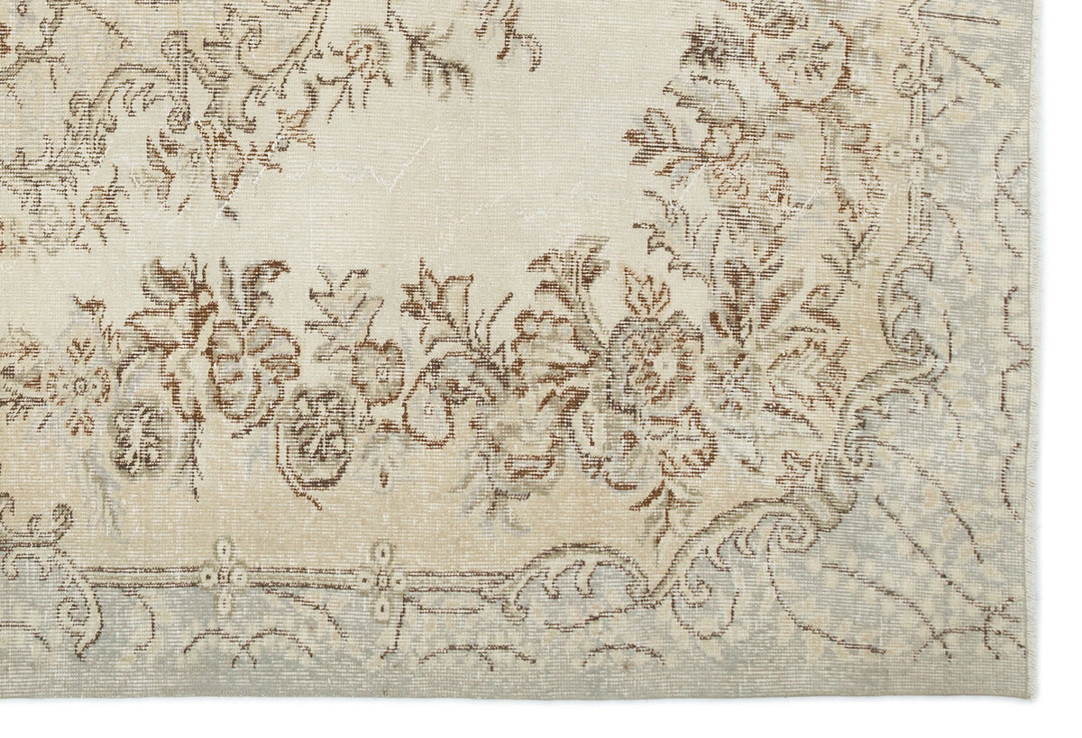 Cream and beige vintage-style rug with a distressed floral medallion pattern and a faded border.