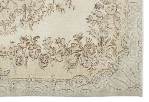 Load image 1 in gallery view. Cream and beige vintage-style rug with a distressed floral medallion pattern and a faded border.