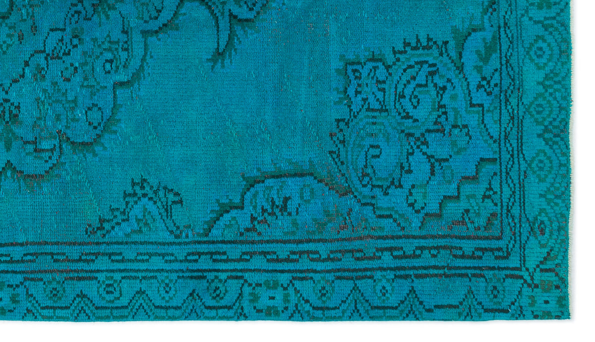 Teal rug with a dark green traditional floral medallion pattern and a geometric border.