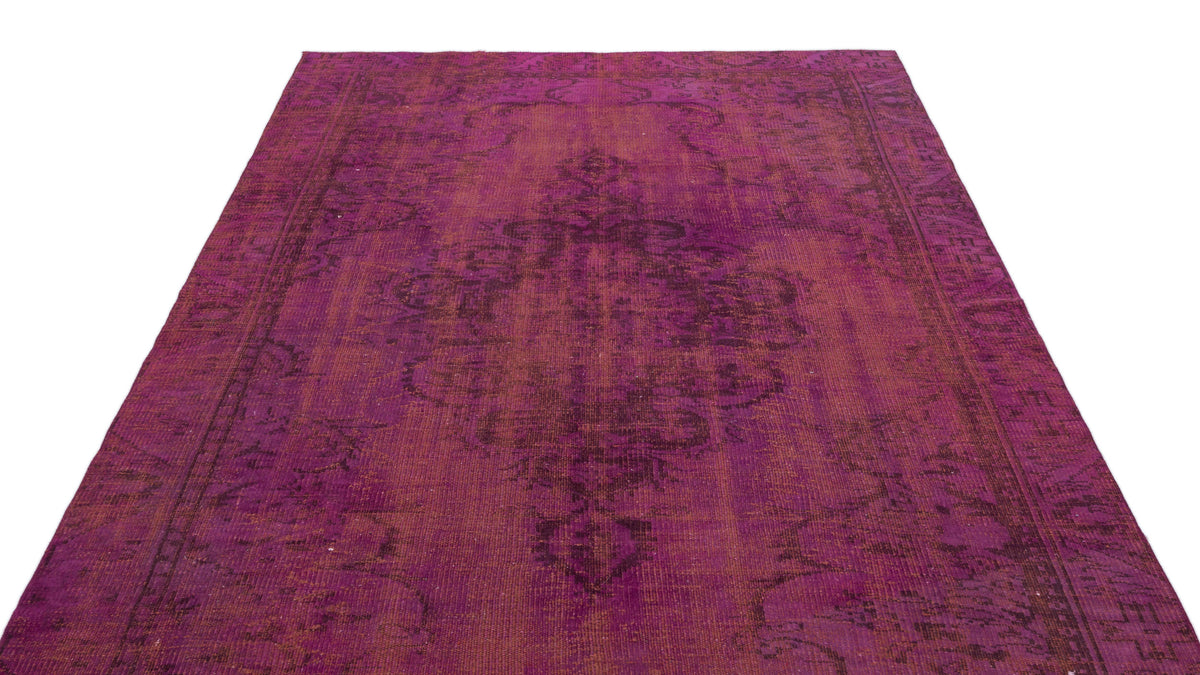 Magenta and dark purple distressed vintage-style rug with a central medallion and ornate border.