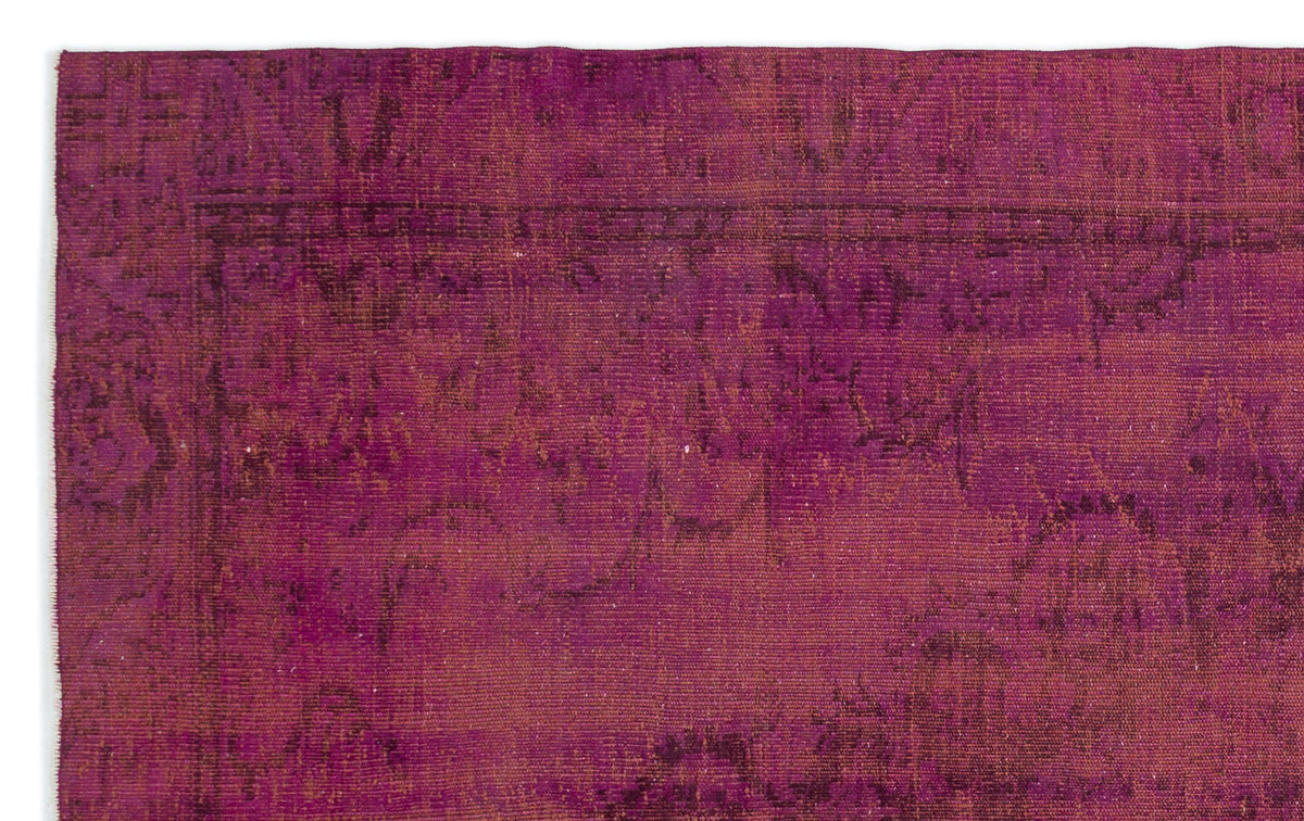 Magenta and deep purple distressed rug with a faded traditional medallion pattern.