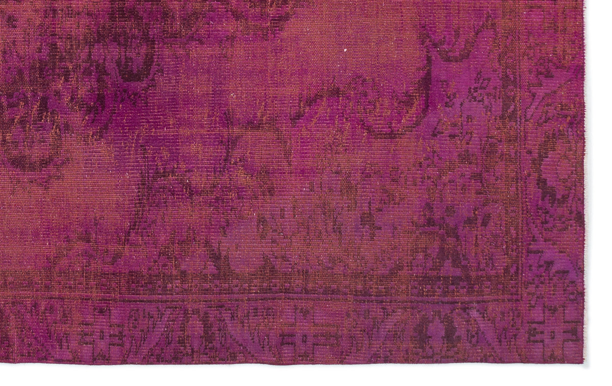 Magenta and deep purple distressed rug with a traditional ornate border and faded floral pattern.