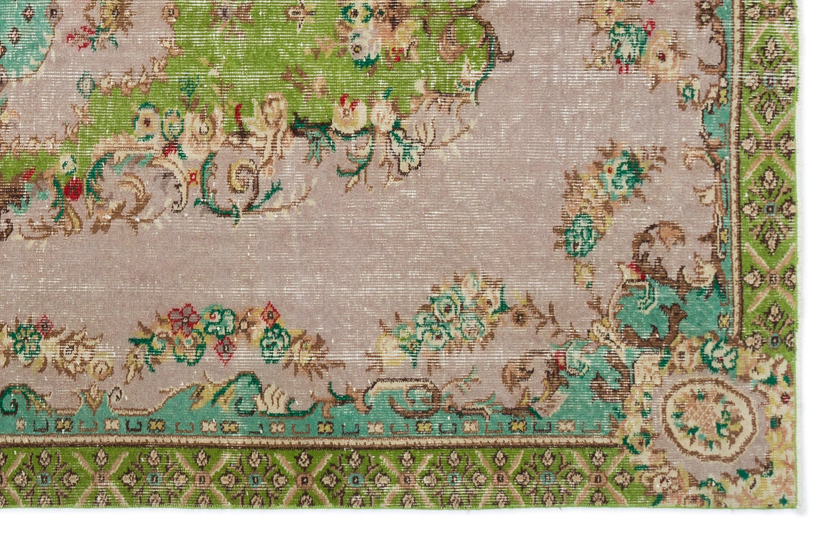 Distressed lavender rug with green floral medallions and a geometric border on a white background.