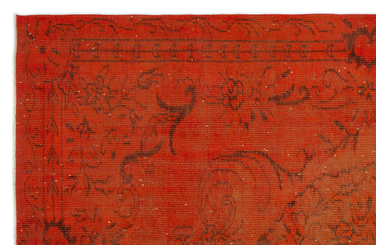 Vibrant red rug with a dark brown, distressed floral and geometric border pattern.