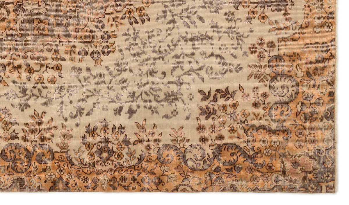 Beige, orange, and charcoal grey rug with a distressed floral and vine pattern.