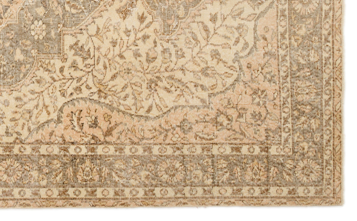 Beige and taupe traditional rug with a distressed floral medallion pattern and a detailed geometric border.