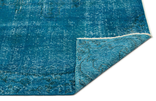 Load image 1 in gallery view. Teal distressed rug with a faded traditional pattern and a folded corner showing the woven backing.