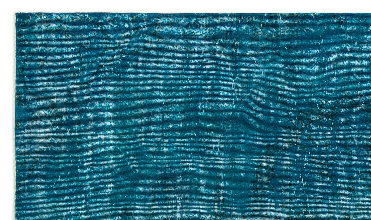 Teal distressed rug with a faded, worn-in texture and subtle dark charcoal ornamental outlines.