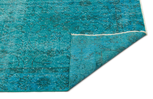 Load image 1 in gallery view. Teal distressed rug with a faded traditional floral pattern and a folded corner, isolated on a white background.