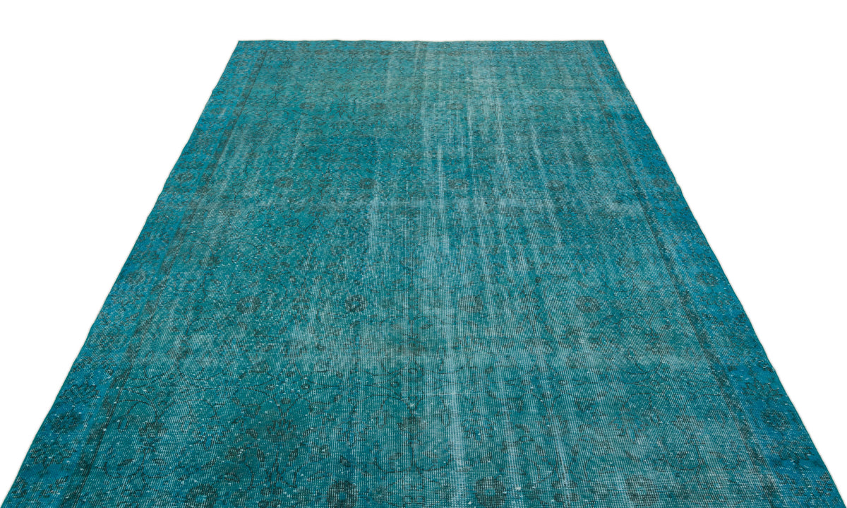 Teal distressed area rug with a faded traditional medallion pattern on a white background.