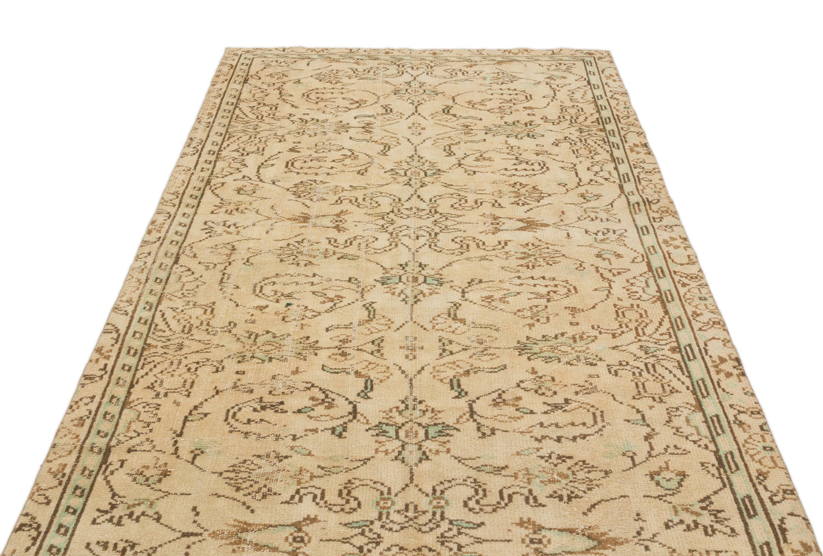 Beige and brown vintage-style rug with a distressed floral medallion pattern and a decorative border.