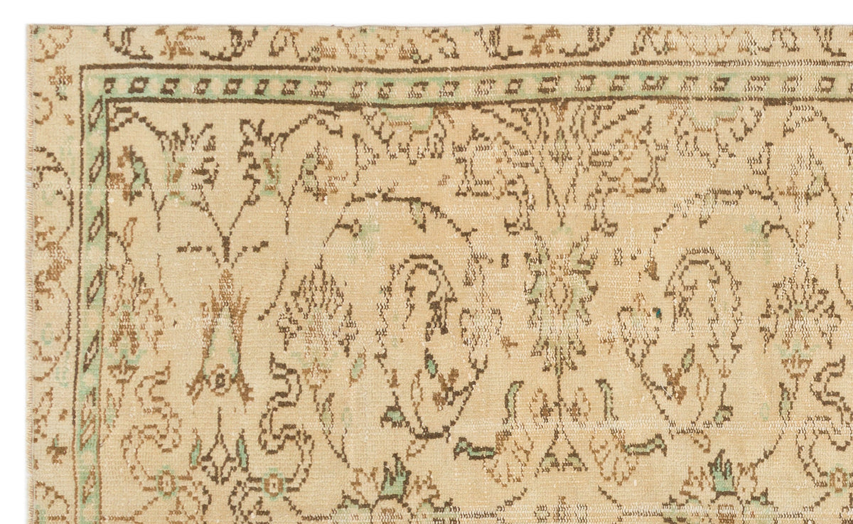 Beige vintage-style rug with brown and sage green floral motifs and a geometric border.
