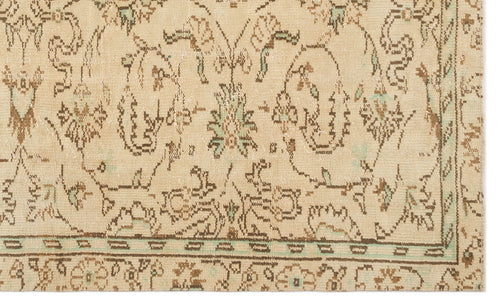 Load image 1 in gallery view. Beige rug with a distressed brown and mint green floral medallion pattern and a geometric border.