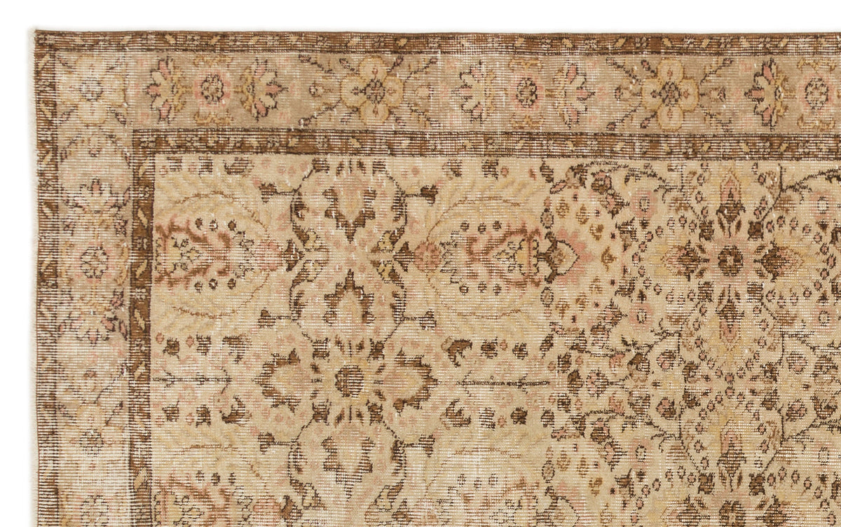 Distressed beige and brown rug with a traditional floral medallion pattern and a decorative border.