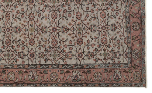 Load image 1 in gallery view. Beige rug with a muted floral vine pattern in pink, sage green, and charcoal, featuring a wide decorative floral border.