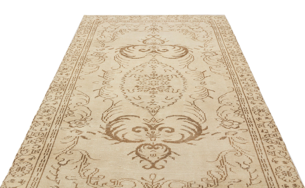 Beige and tan traditional rug with a central floral medallion and ornate border pattern on a white background.