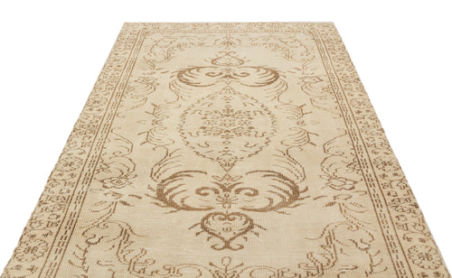 Load image 1 in gallery view. Beige and tan traditional rug with a central floral medallion and ornate border pattern on a white background.