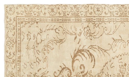 Load image 1 in gallery view. Beige and tan rug with a distressed traditional floral medallion pattern and a geometric border.