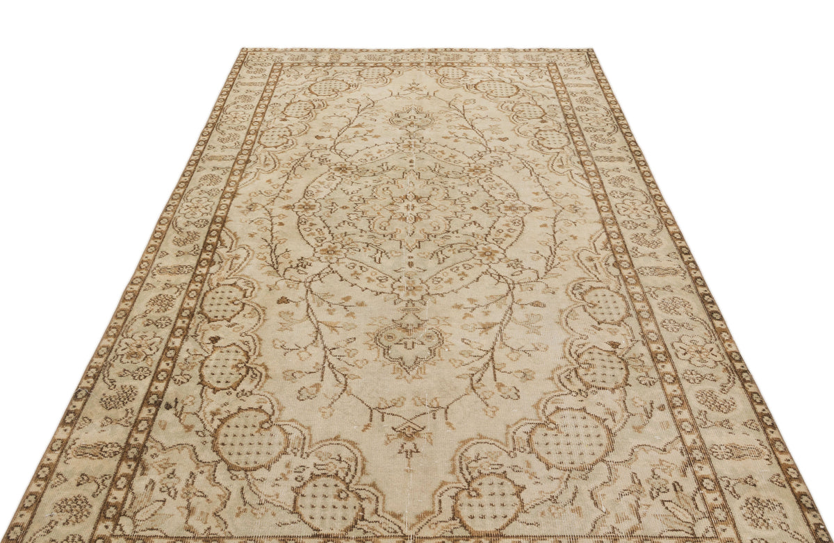 Beige and brown vintage-style rug with a central floral medallion and intricate botanical border on a white background.