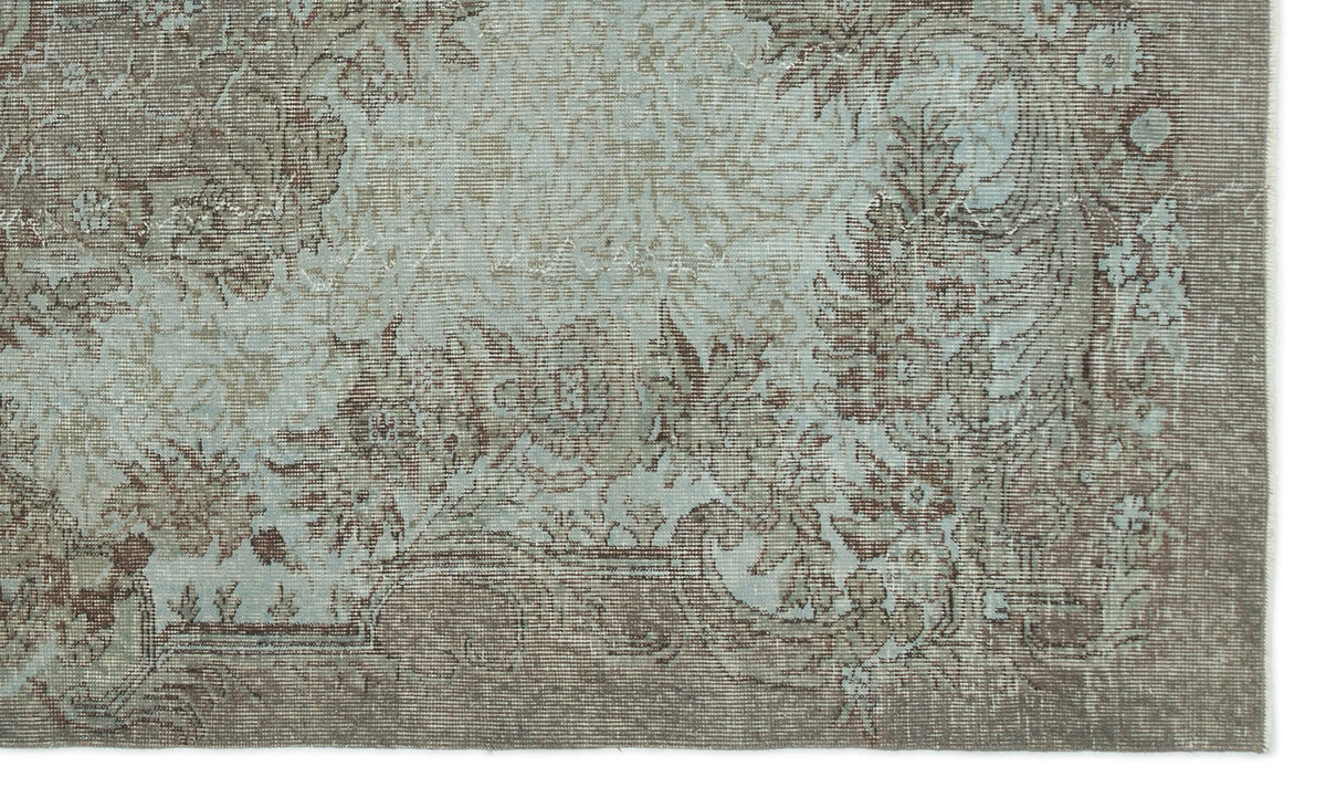 Distressed taupe and light blue rug with a traditional floral medallion pattern and ornate border.