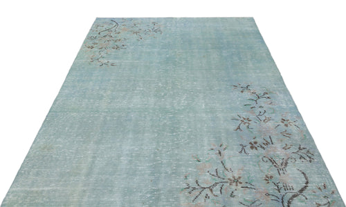 Load image 1 in gallery view. Distressed light blue rug with a faded floral branch pattern in the corners on a white background.