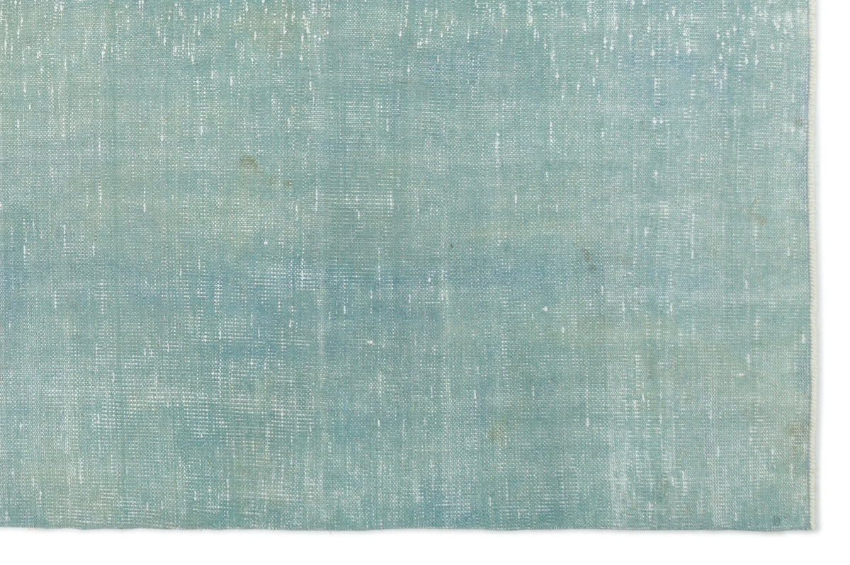 Solid light blue rug with a distressed, weathered texture and visible white woven detailing.