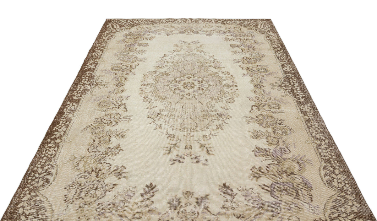 Beige and brown vintage-style rug with a central floral medallion and ornate border on a white background.