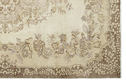 Load image 1 in gallery view. Beige and brown vintage-style rug with a faded floral medallion pattern and a decorative border.