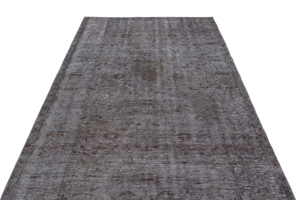 Charcoal and grey distressed vintage-style rug with a faded traditional medallion pattern on a white background.