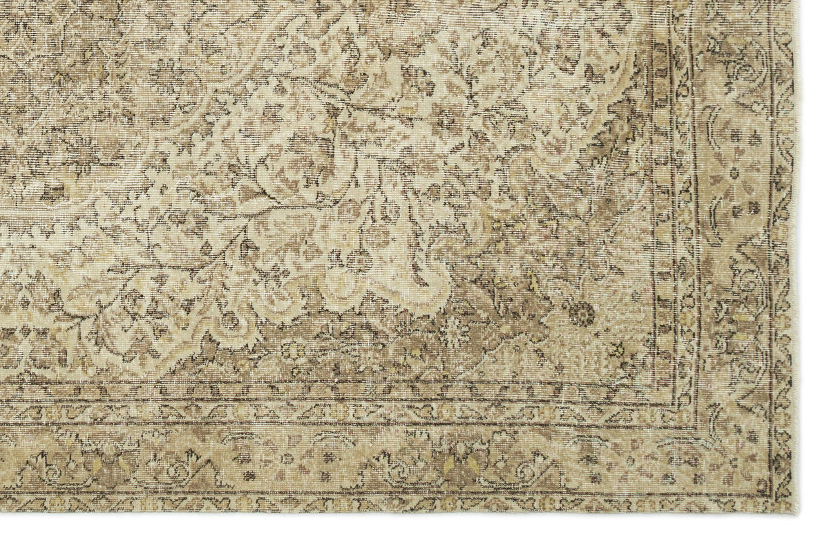 Beige and brown traditional rug with a distressed floral medallion pattern and a detailed border.