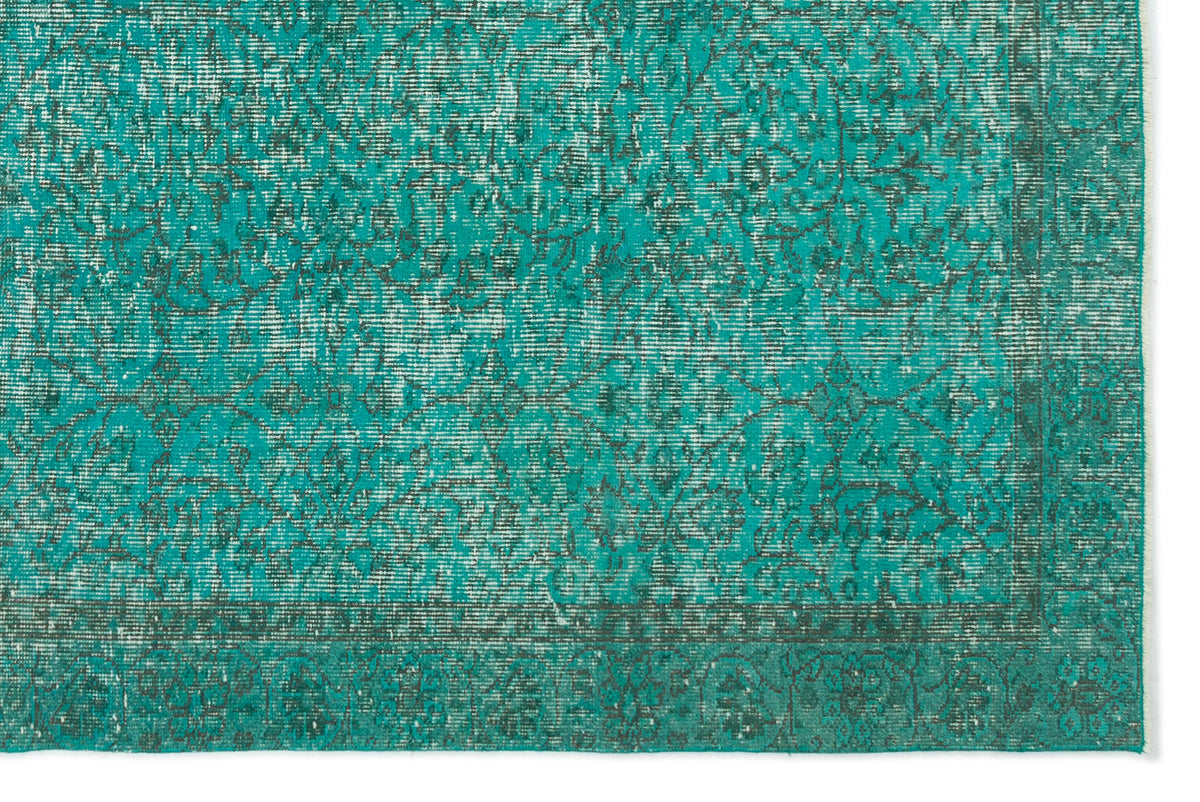 Teal and dark grey distressed rug with a traditional floral medallion pattern and a bordered edge.
