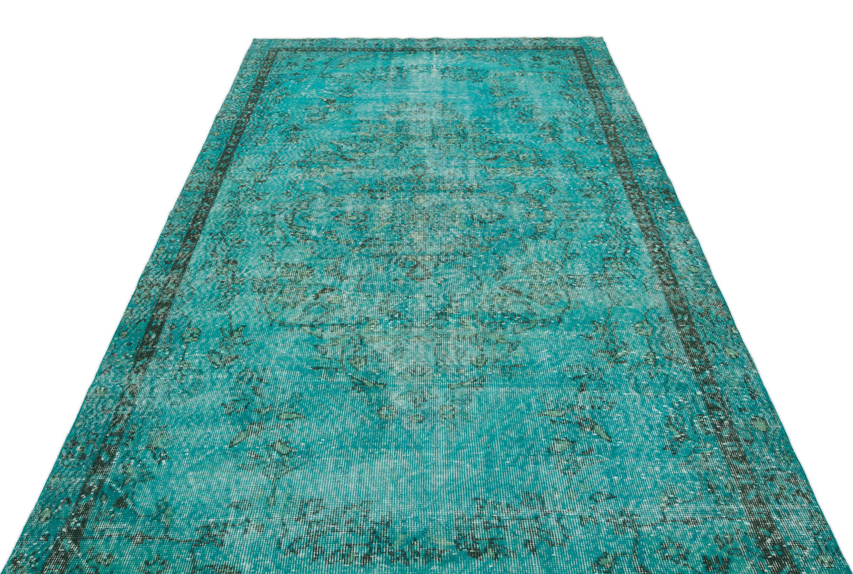 Distressed turquoise and black traditional rug with a central medallion and ornate border on a white background.