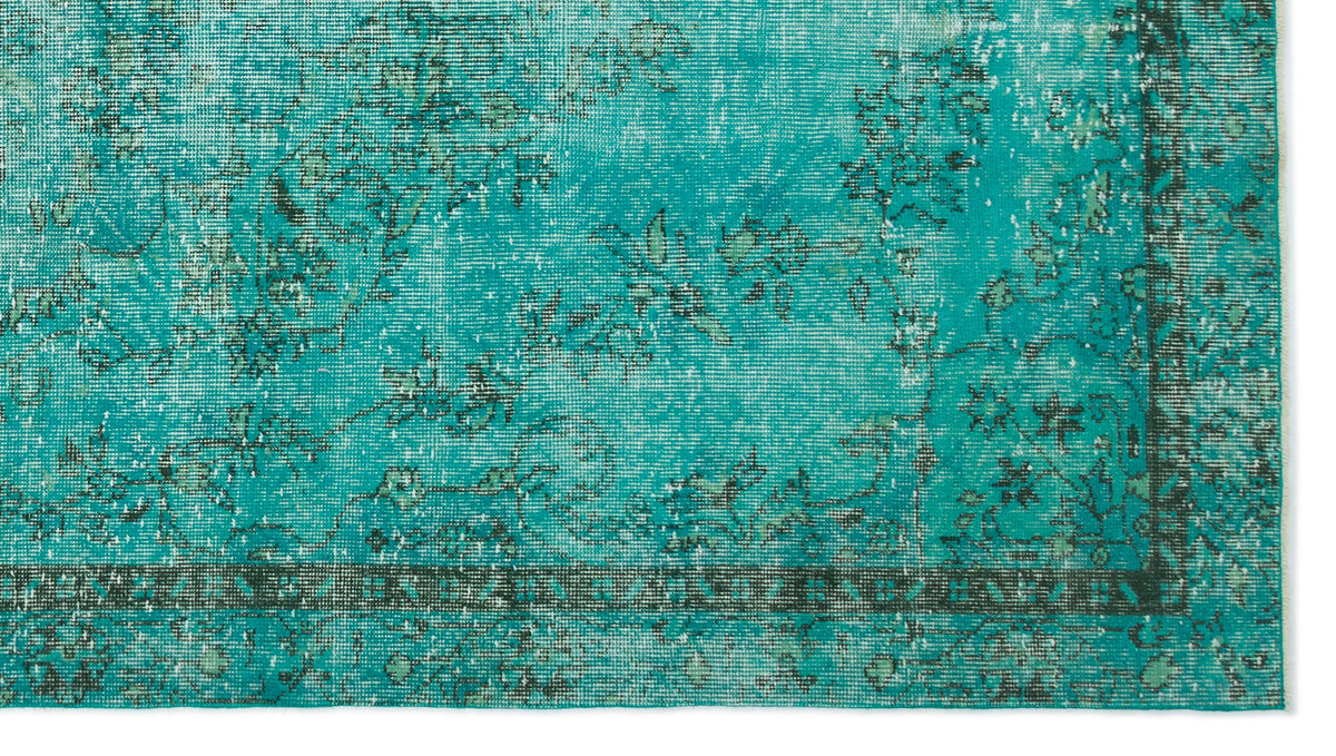 Teal distressed rug with a dark green floral border and faded traditional pattern.