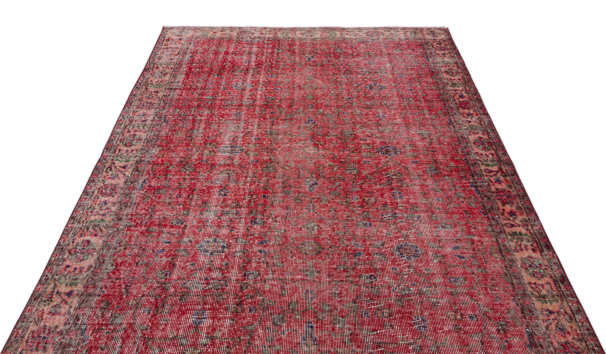 Distressed red vintage-style rug with a faded floral medallion pattern and intricate border on a white background.